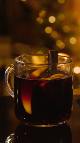 Vertical-Video-Of-At-Home-With-Glass-Of-Mulled-Wine-On-Table